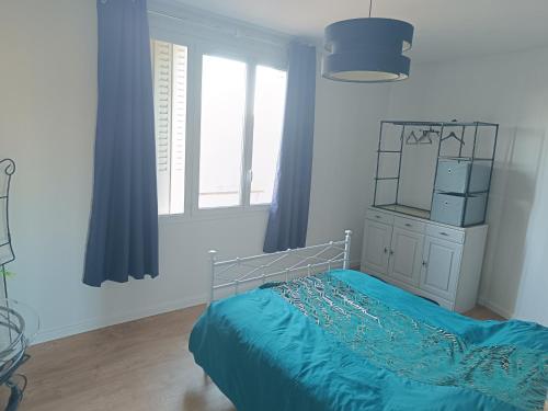 une chambre avec un lit avec des draps bleus et une fenêtre dans l'établissement Mikelimoges, à Limoges