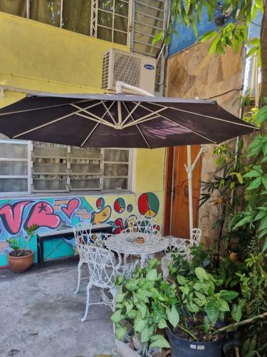 圣保罗Hostel Dumah - santana的露台的遮阳伞下的桌椅