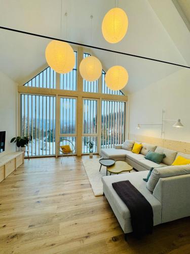 - un salon avec deux canapés et de grandes fenêtres dans l'établissement Apartmány Motýlí louka, à Albrechtice v Jizerských horách