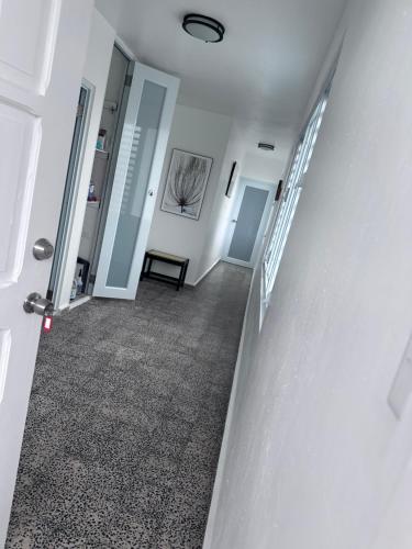 a hallway with white walls and a staircase with a bench at El AMANECER DEL ESTE in Fajardo
