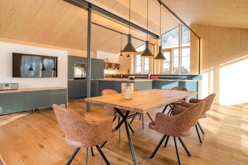 a kitchen and dining room with a wooden table and chairs at Alpenhaus Chalet Panoramablick - Bergbahn unlimited inklusive in Oberstdorf