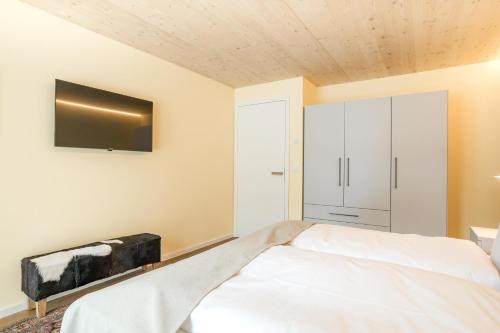 a bedroom with a bed and a tv on the wall at Alpenhaus Chalet Panoramablick - Bergbahn unlimited inklusive in Oberstdorf