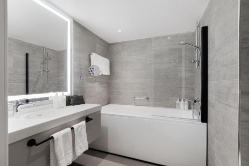 a bathroom with a tub and a sink and a shower at Original Sokos Hotel Vantaa in Vantaa