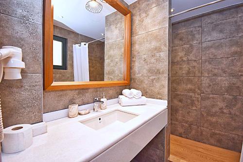 un baño con lavabo y espejo en Άρκτος ΟΕ, en Pelekas