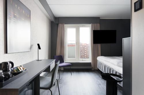 a hotel room with a desk and a bed and a window at Original Sokos Hotel Vantaa in Vantaa
