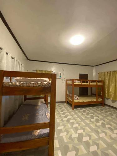 a room with three bunk beds in it with a ceiling at 4A's Lodging in Daanbantayan