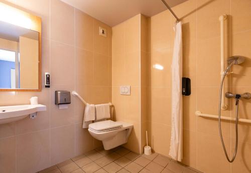a bathroom with a shower and a toilet and a sink at B&B HOTEL Grenoble Centre Alpexpo in Grenoble