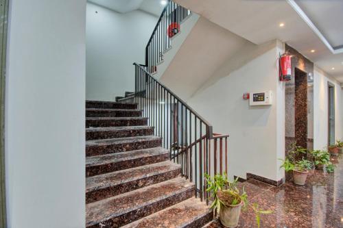 a staircase in a building with potted plants at Hotel O Shiv Mahima in Jaipur