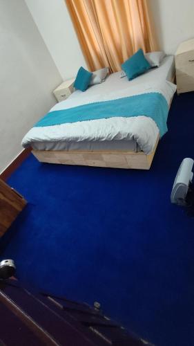 a bedroom with a bed with a blue floor at Chandramouli Homestay in Harsil