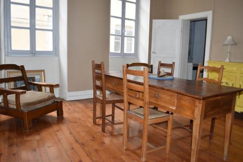 une salle à manger avec une table et des chaises en bois dans l'établissement Appartement de caractère, à Bourg