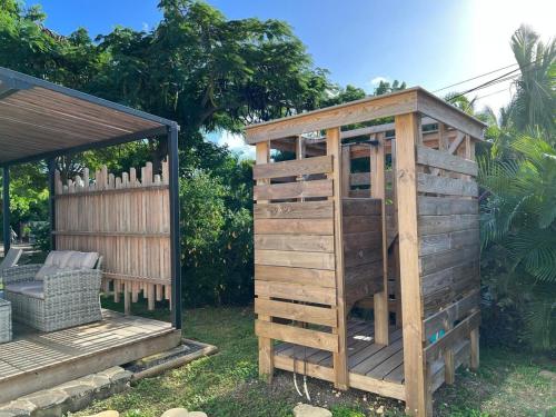 a wooden play house next to a gazebo at Ecolodge Barbuda - Natural pool & beach in Saint-François
