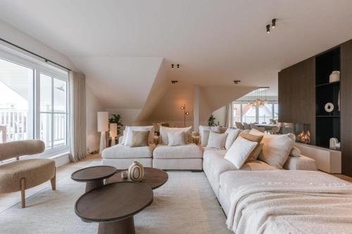 Una sala de estar con un sofá grande y una mesa. en Seaholiday Nieuwpoort met zicht op de jachthaven, en Nieuwpoort