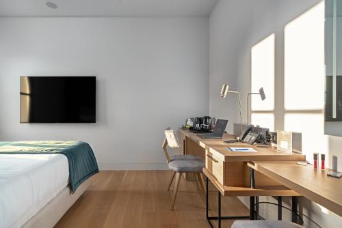 a hotel room with a bed and a desk with a computer at Hellenic Vibes Smart Hotel in Athens