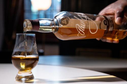 a person pouring a glass of beer at Taj Cape Town in Cape Town
