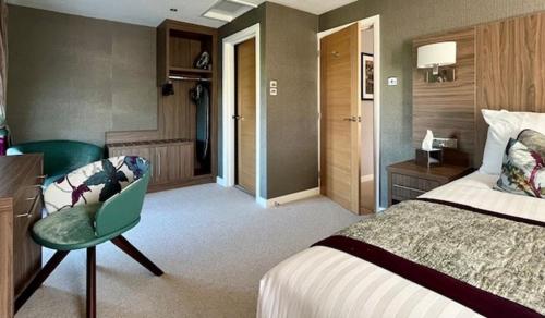 a large hotel room with a bed and a chair at The Melbreak Hotel in Great Clifton