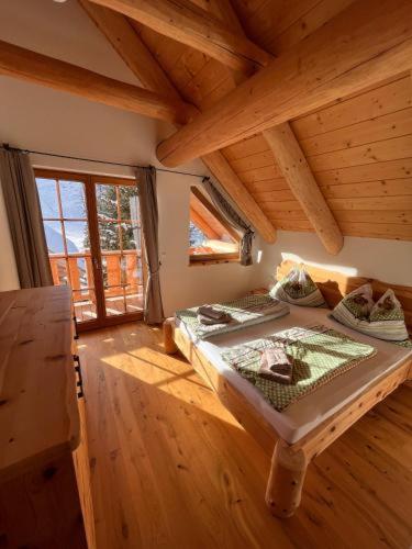 a bedroom with two beds in a room with wooden floors at Bründl-Chalets Hochrindl in Sirnitz-Sonnseite