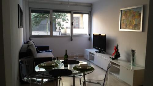 a living room with a table and a television at Apartment LPA STOP- Las Canteras in Las Palmas de Gran Canaria