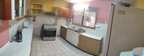 Una pequeña cocina con fregadero y refrigerador. en Casa 11 septiembre primera etapa, en Arica