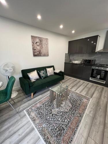 a living room with a green couch and a table at Guest house in london in Edgware