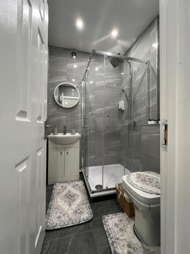 a bathroom with a shower and a toilet and a sink at Guest house in london in Edgware