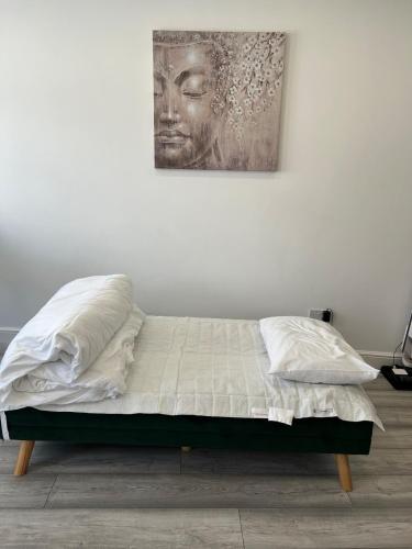 a bed in a bedroom with a painting on the wall at Guest house in london in Edgware