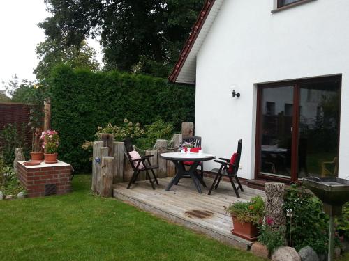 a patio with a table and chairs in a yard at Ferienhaus Utspannen in Prerow