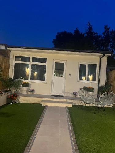 a house with two chairs and a lawn at night at Guest house in london in Edgware