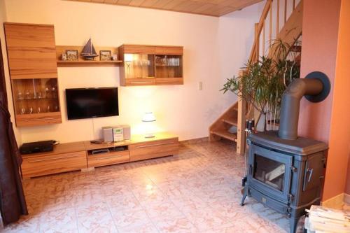 a living room with a wood stove and a television at Ferienhaus Utspannen in Prerow
