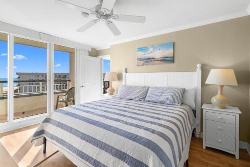 a bedroom with a bed with a blue and white striped blanket at 5th Flr Oceanfront 2 Bedroom Condo in Pawleys Island