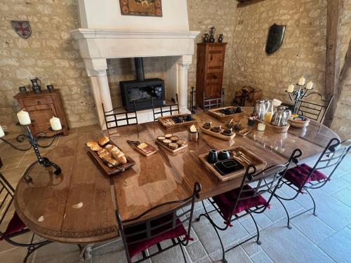a large wooden table in a room with a fireplace at Le Relais des Chevaliers "La Suite des Seigneurs" in Cordes-sur-Ciel