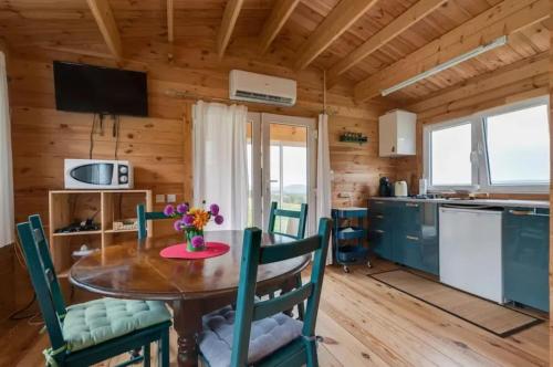 une cuisine et une salle à manger avec une table et des chaises dans l'établissement Chalet accueillant à Égliseneuve-des-Liards avec jardin, à Égliseneuve-des-Liards