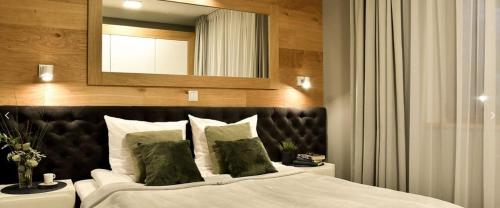 a bedroom with a large bed with a large mirror at Apartamenty Forma Tatrica in Zakopane