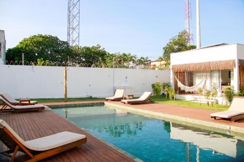 una piscina con sedie a sdraio accanto a un edificio di Pipa Casas Blancas Residencial a Pipa