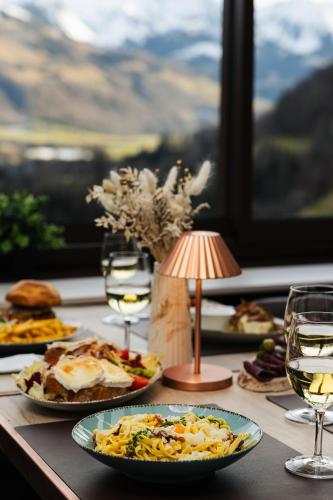 a table with plates of food and glasses of wine at Le Saint Georges in Gruyères