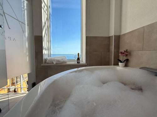 a bath tub filled with snow in a bathroom with a window at Alema apartment Giardini Naxos in Giardini Naxos