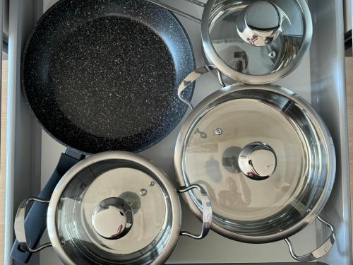 a group of four metal pans in a drawer at VALEMI BohoChic I 2BR 6PAX I TopLage I Parkplatz I Balkon I Küche in Landsberg am Lech