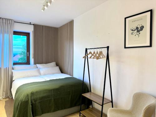 a bedroom with a bed and a chair at VALEMI BohoChic I 2BR 6PAX I TopLage I Parkplatz I Balkon I Küche in Landsberg am Lech