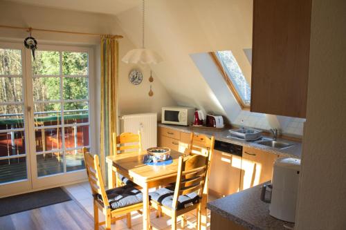 a kitchen with a wooden table and chairs in a kitchen at Am Bernsteinweg in Prerow