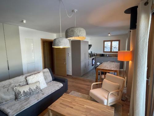 un salon et une cuisine avec un canapé et une table dans l'établissement Chalet de l'Olympe, à Les Allues