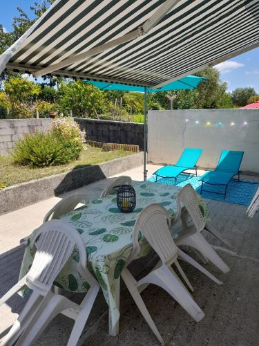 une table et quatre chaises sous un auvent dans l'établissement Location vacances Royan, à Royan