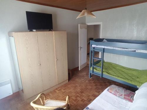 - une chambre avec un lit superposé bleu et une télévision dans l'établissement Location vacances Royan, à Royan