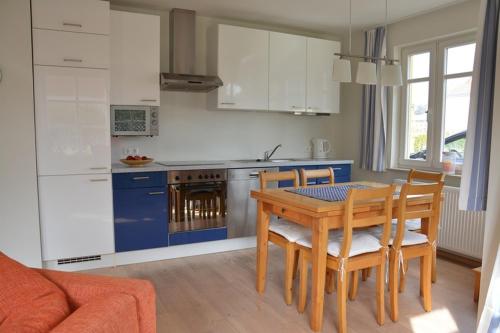 a kitchen with a table and chairs and a dining room at Hagens Hus in Prerow