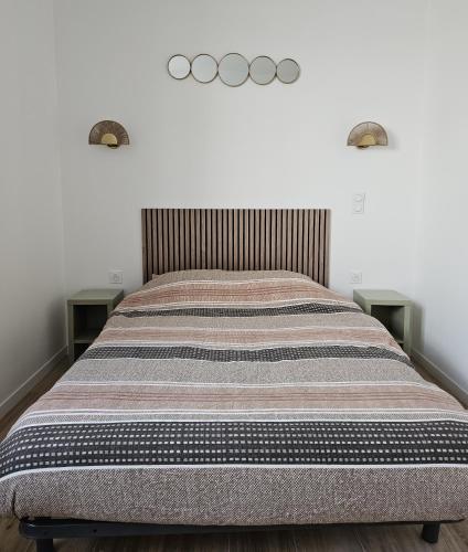 - un lit avec deux photos olympiques sur le mur dans l'établissement Petite maison, Oyonnax centre, à Oyonnax