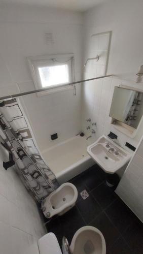a white bathroom with a toilet and a sink at Departamento bolivar in Mar del Plata