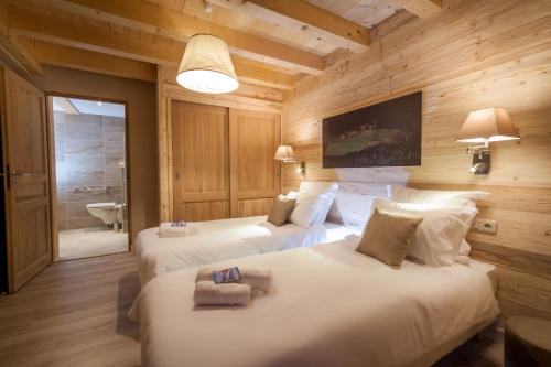 una camera con due letti e un bagno di Les Couadzous Samoëns Centre, Sauna, Jacuzzi, 6 chambres, 7 salles de bains, 16 pers 250 m2 a Samoëns