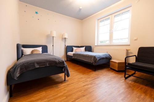 a bedroom with a bed and a couch and a chair at SmartFewo - Home - Zentral - Terrasse - Parkplatz in Oldenburg