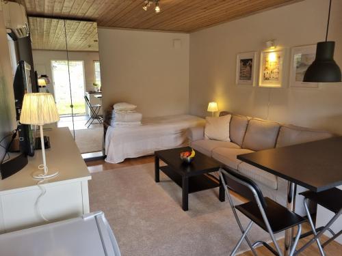 a living room with a couch and a table at Lantlig lägenhet nära Uppsala in Uppsala