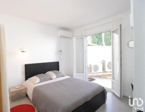 une chambre blanche avec un lit et une grande fenêtre dans l'établissement Villa Anza de la Olla - Le Racou plage - 13 personnes - 5 chambres, à Argelès-sur-Mer