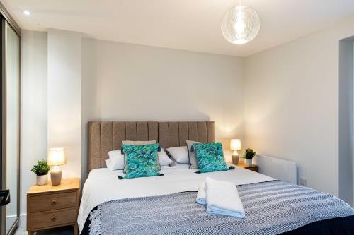 a bedroom with a large bed with blue pillows at Rock Mill 1 Bed Apartment 37 in Stoney Middleton