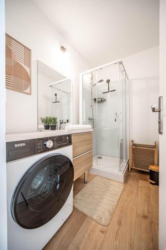 une machine à laver dans une salle de bain avec douche dans l'établissement Le temps d'une pause, à Chalon-sur-Saône